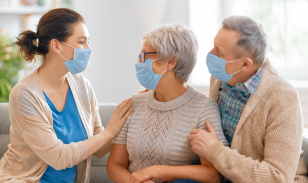 Adult daughter and senior parents wearing facemasks during coronavirus and flu outbreak. Virus and illness protection, home quarantine. COVID-2019